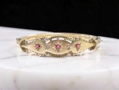 A late Victorian 9ct gold ruby and diamond hinged bangle, inner width 5.