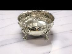 A Victorian embossed silver four-footed bowl, maker indistinct, London 1864, diameter 14cm.