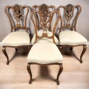 A set of four carved walnut dining chairs.