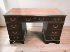 A reproduction mahogany nine drawer twin pedestal desk with tooled leather inset top,