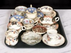 A group of decorative teacups and coffee cans with saucers.