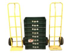 Two sack barrows and a group of plastic stacking boxes.