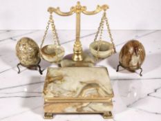 An onyx trinket box, width 12 cm, similar set of scales, pair of polished eggs on stands.
