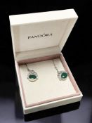 A pair of silver and green stone swivel fob earrings in an associated Pandora box.