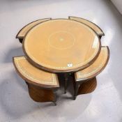 A reproduction mahogany and tooled leather circular coffee table with four stowaway tables beneath,