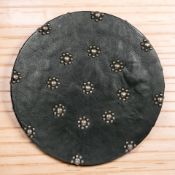 A reproduction Scottish shield / targe covered in black leather with metal studs, diameter 46 cm.