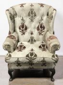 A 20th century wing back armchair in buttoned grey upholstery, width 85 cm.