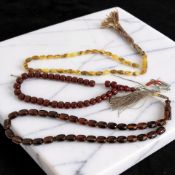A group of amber and cherry-coloured bead necklaces