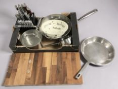 A knife block, various stainless steel pans, chopping board, etc.