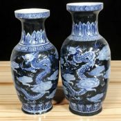 A graduated pair of 20th century Chinese famille noire baluster vases, tallest 49 cm.