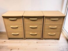 A set of three Alstons Furniture teak veneered three drawer bedside chests, width 47 cm.