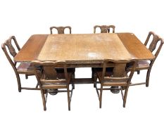 An early 20th century carved oak eight piece dining room suite comprising of triple door sideboard