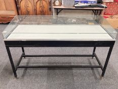 A contemporary glazed table display case raised on metal base,