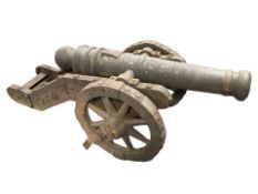 An antique cast iron non-firing cannon on carriage, length 160 cm.