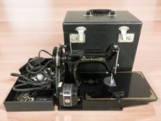 A Singer Featherweight sewing machine in case with lead and pedal.