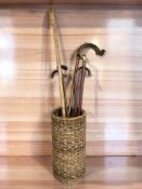 A wicker stick pot containing several walking sticks and a shepherd's crook.