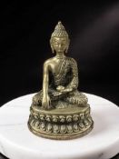 A cast patinated metal figure of Buddha seated in lotus pose, height 15 cm.