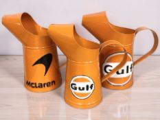 Three reproduction oil cans with Gulf and Mcclaren advertising, tallest 32 cm.