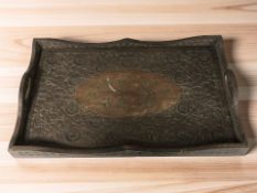 An eastern heavily carved and brass inlaid serving tray, width 53 cm.