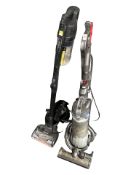 A Dyson DC25 vacuum cleaner and a Shark vacuum cleaner.