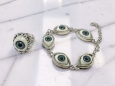 A white metal dress ring set with an 'Eye' together with matching bracelet