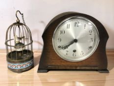 An early 20th century oak mantel clock, width 26 cm, and an enameled metal bird cage clock.