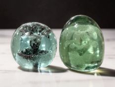 Two Victorian Sunderland green glass dumps with flower sulphide inclusions, tallest 8 cm.