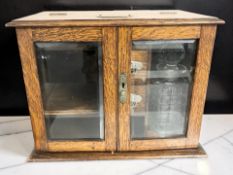 An early 20th century oak double door smoker's cabinet,