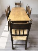 An Edwardian oak 6 ft refectory dining table, together with a set of six rush seated chairs.