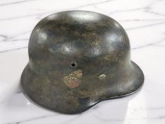 A German Third Reich M35 Stahlhelm, with Prussian Eagle and German flag decals to either side,