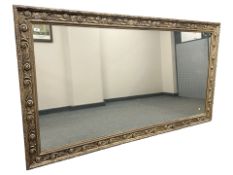 A large contemporary gilt framed over mantel mirror, 121 cm x 221 cm.