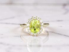 A silver gilt cluster dress ring set with 2ct natural peridot and cubic zirconia,