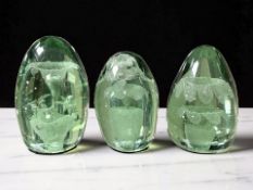 Three Victorian Sunderland green glass dumps with flower sulphide inclusions, tallest 12.5 cm.