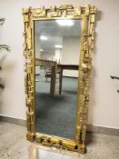 A contemporary American brutalist style gilt wall mirror, 107 cm x 51 cm.