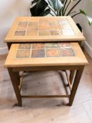 A teak and tile inset nest of two tables, width 49 cm.