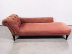A 20th century chaise longue, in buttoned red upholstery, length 191 cm.