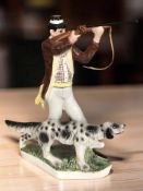 A figural decanter in the form of a man shooting game with a gun dog at his feet,