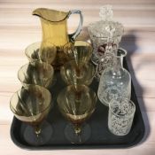 An amber glass water pitcher and six matching glasses, an etched decanter,