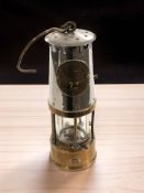 A brass and chrome Eccles Protector Type 6RS miner's safety lamp.