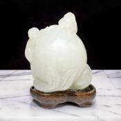 A Chinese mutton jade carving of monkeys climbing atop a large peach, Qing Dynasty, 19th century,