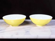 A pair of Chinese porcelain tea bowls on yellow ground,