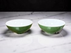 A pair of Chinese porcelain tea bowls on green ground,