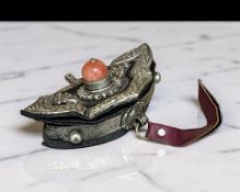 A Tibetan leather pouch, with white metal mounts and red hard stone cabochon, width 11 cm.