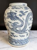A large Chinese blue and white porcelain bulbous urn decorated with five clawed dragons amongst