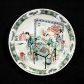 A Chinese famille verte porcelain charger decorated with a group of ladies playing Goh,