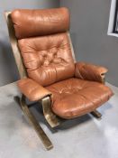 A Scandinavian stained bentwood and buttoned tan leather lounge armchair, width 78 cm.