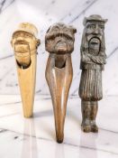 A Black Forest carved oak figural nut cracker, 19th century, length 21cm, together with two others.