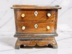 A treen money box in the form of a Georgian two-drawer chest, height 13cm.