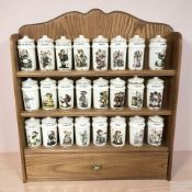 A collection Hummel kitchen spice jars with a wooden spice rack.