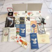 Assorted coins including £5, £2, and £1 presentation packs, first day coin covers,
